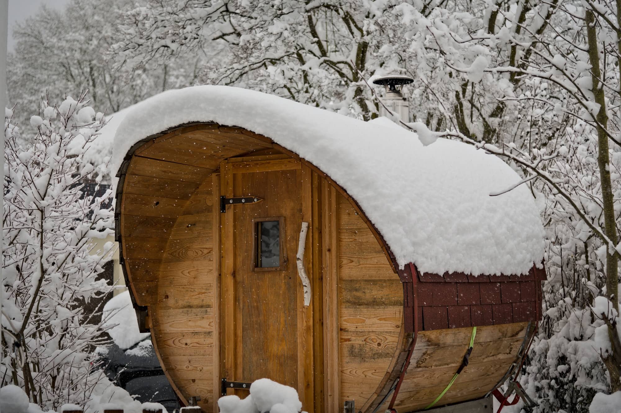 Mobile, selbstgebaute Fasssauna an einem verschneiten Wintertag – der perfekte, gemütliche Rückzugsort.